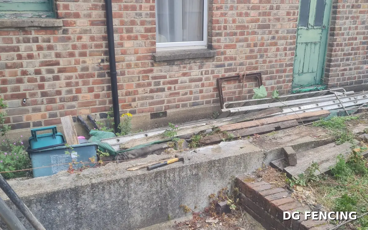 Before: the same garden with no fence, exposed brickwork and building materials