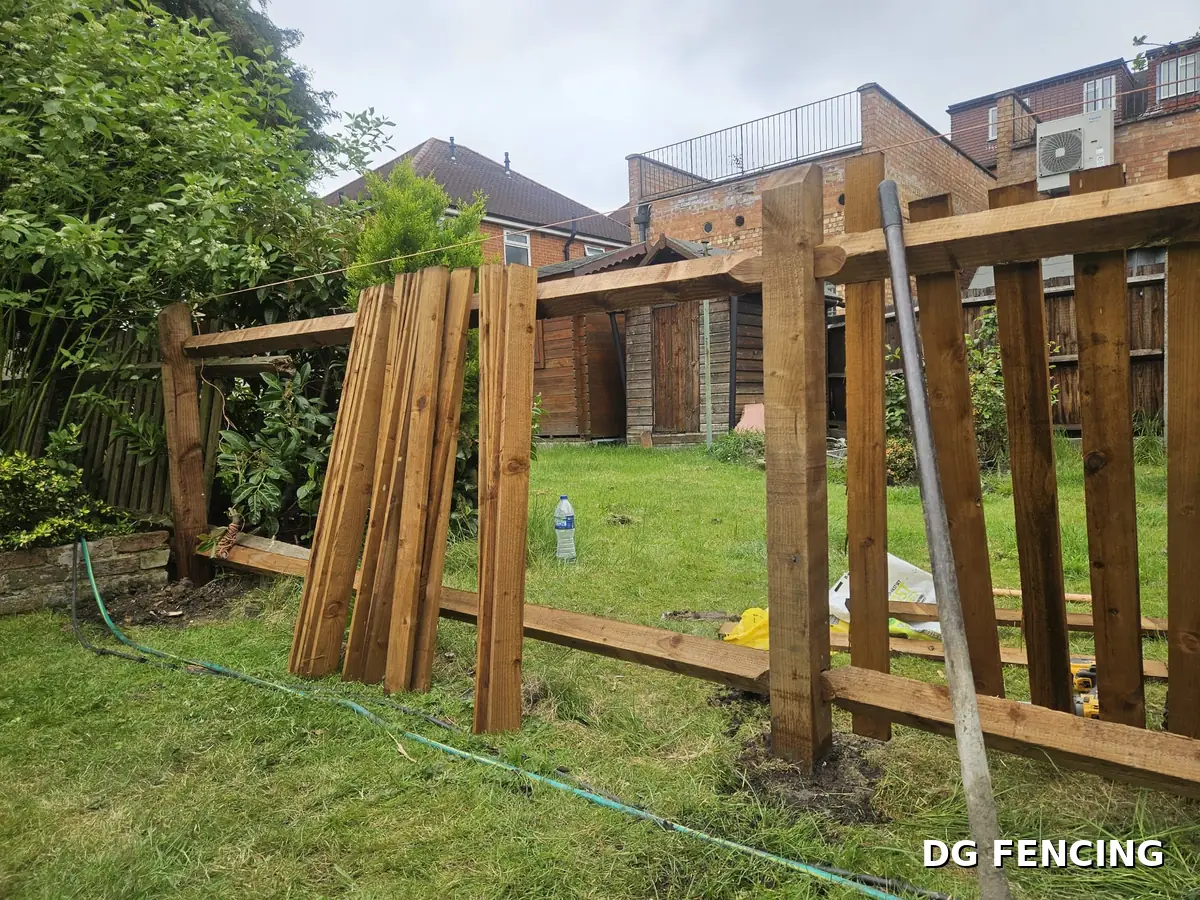 Before: the same boundary mid-build with posts and rails in place